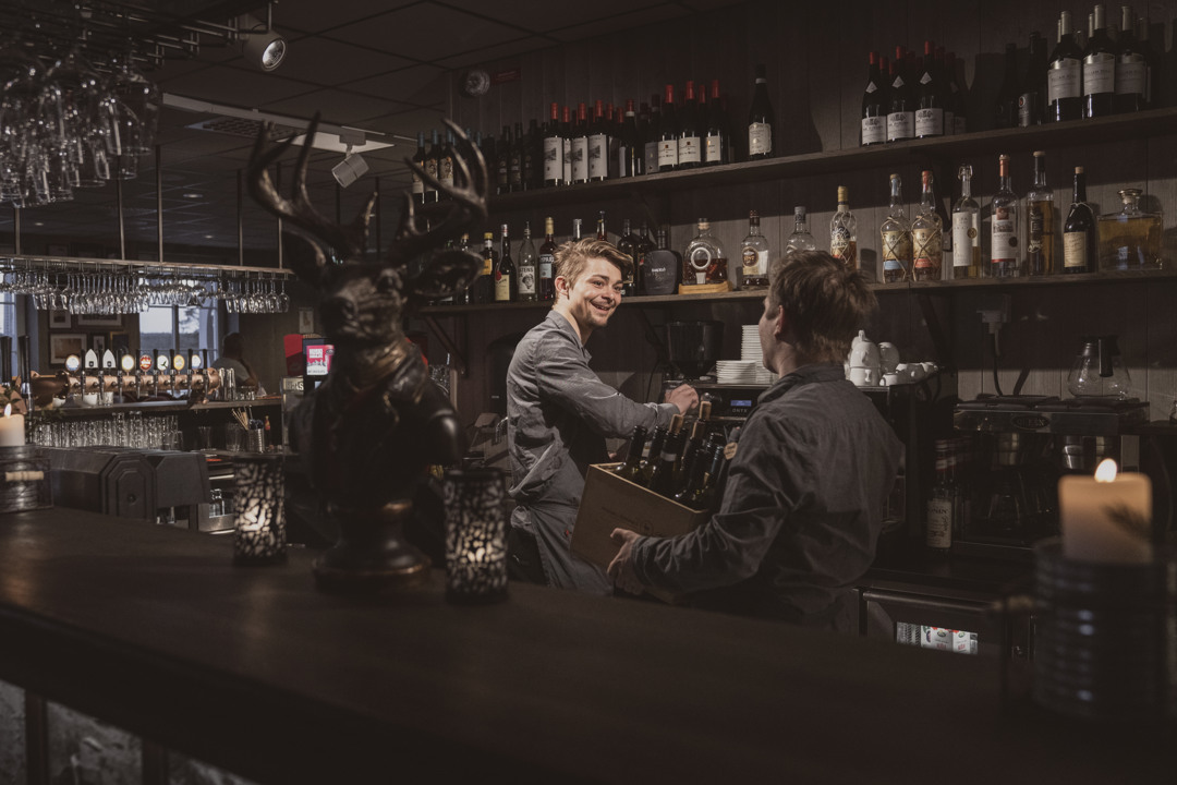 En servitris plockar bland vinflaskor