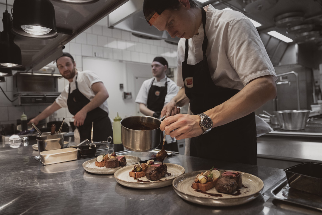Personalen i köket förbereder tallrikar med mat