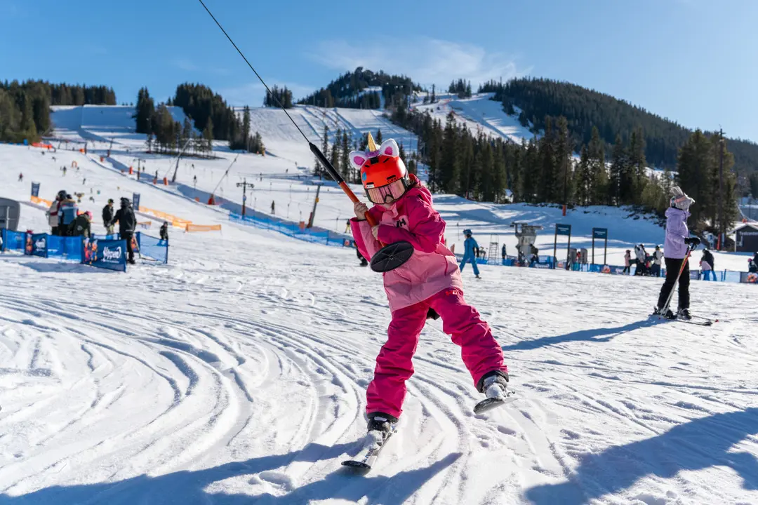 A child rides in the button lift carousel in the children's area